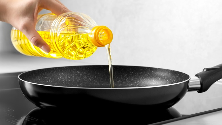 pouring oil into sauté pan