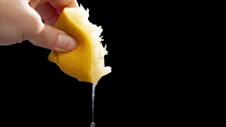 hand squeezing lemon juice