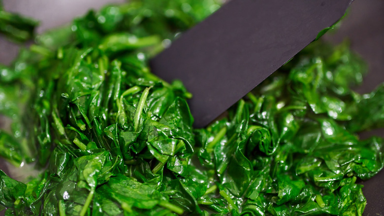 cooked spinach leaves and spatula