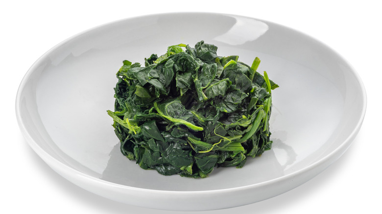 white bowl of cooked spinach 