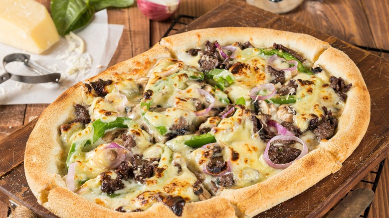 Philly cheesesteak pizza on cutting board