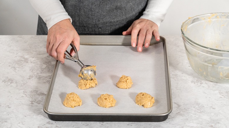 hands scooping cookie dough