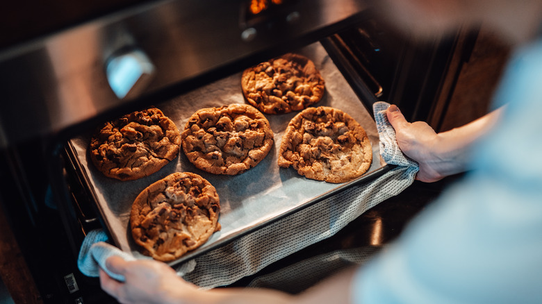 hands taking cookies out of oven