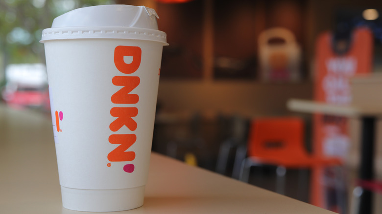 A cup of Dunkin' hot coffee on table inside Dunkin'