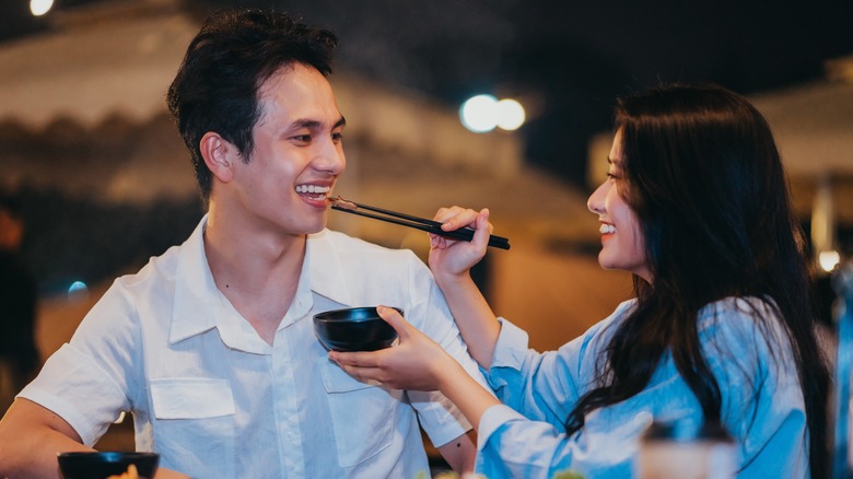 Two people feeding each other