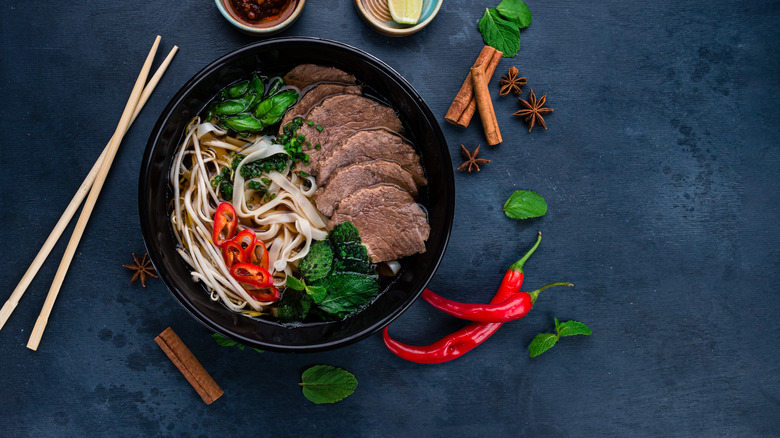 bowl of noodle soup with meat and garnishes