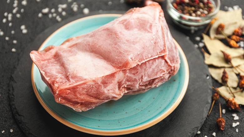 raw meat thawing on plate