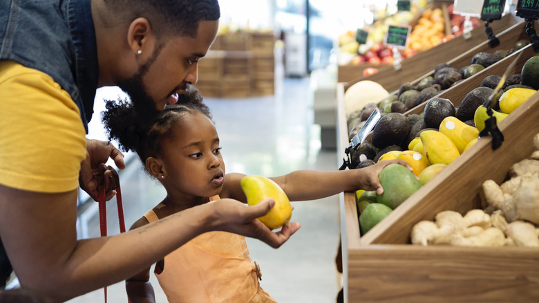 Man and daughter selecting mangoes