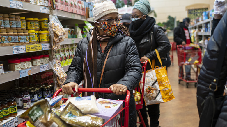 Woman pushing cart, busy store