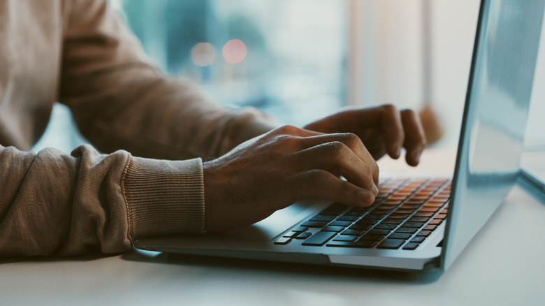 person typing on laptop