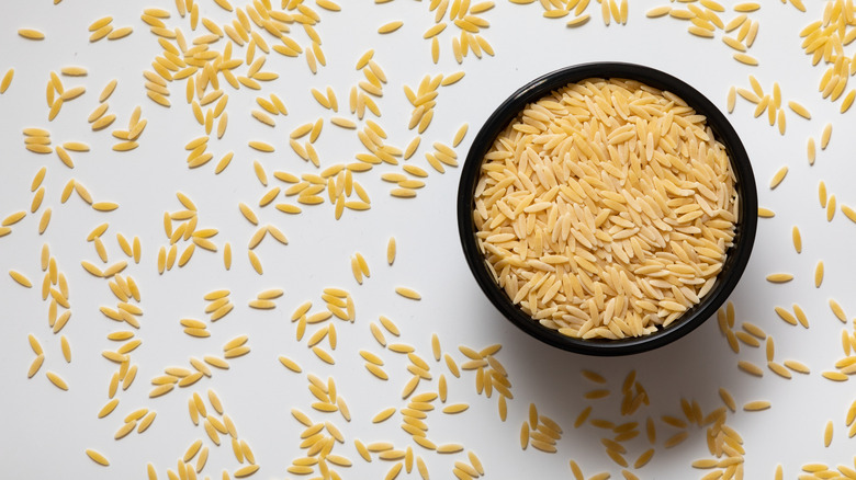 Orzo pasta in and scattered around a bowl