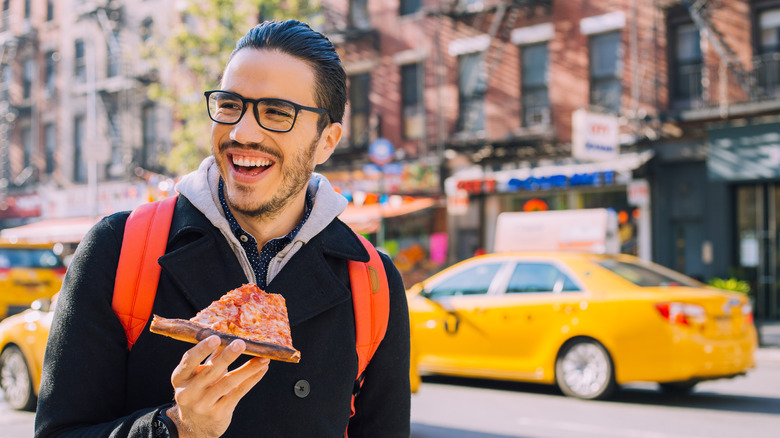 Man eating New York pizza