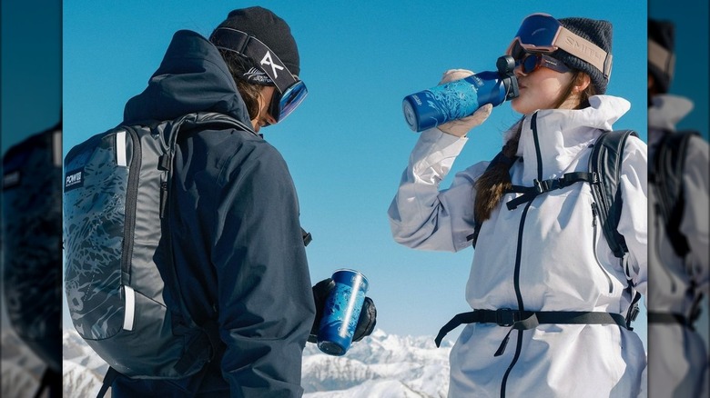 Snowboarders holding water bottles