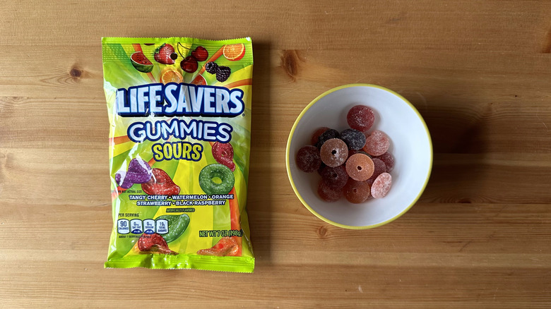 Life Savers Gummies Sours bag with bowl on wooden table