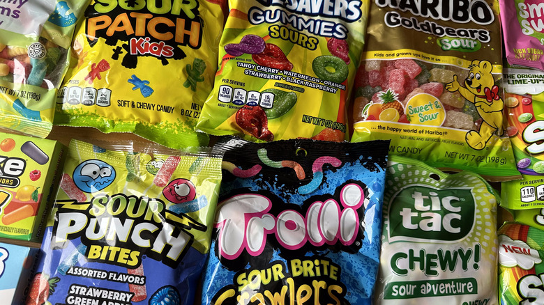 Bags of sour candies on wooden table