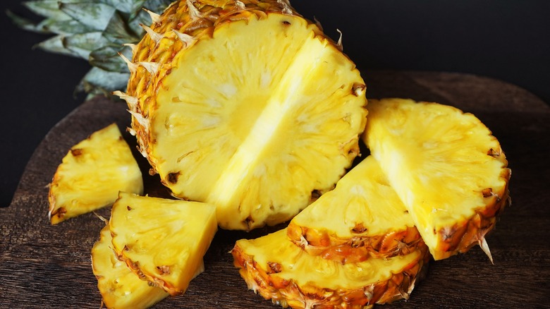 Sliced pineapple on wooden board