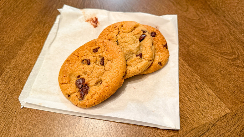 Three chocolate chip cookies on a white wrapper