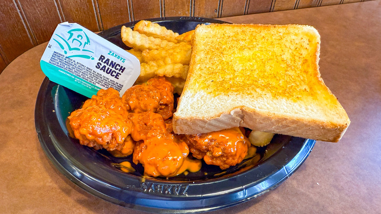 Plate of Zaxby's boneless wings, crinkle fries, Texas toast, and ranch sauce