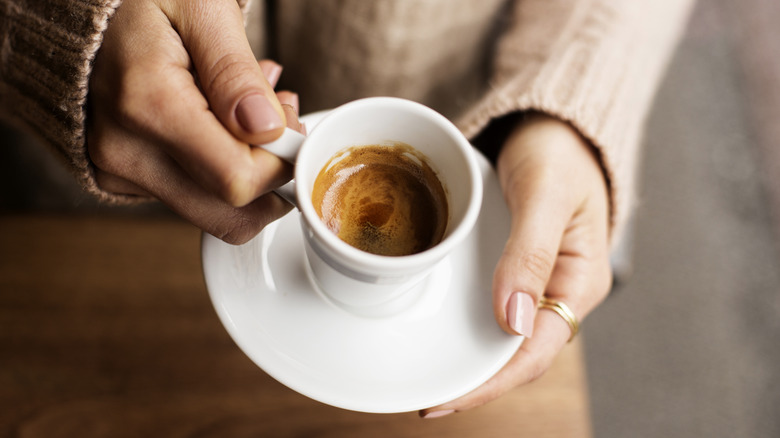 Woman's hands holding espresso cup