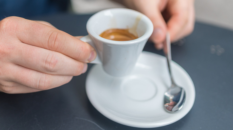 Male hands holding espresso cup