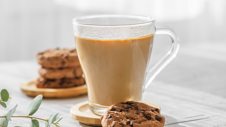 Milky coffee next to cookies 