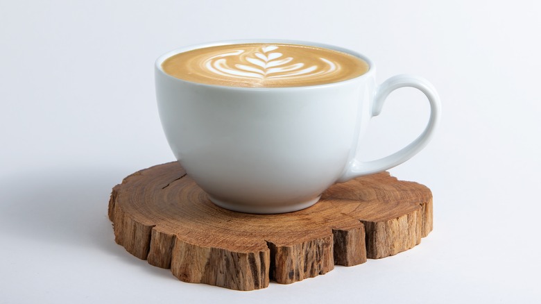 Latte white mug on wooden coaster
