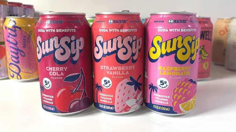Three SunSip cans lined up on white table