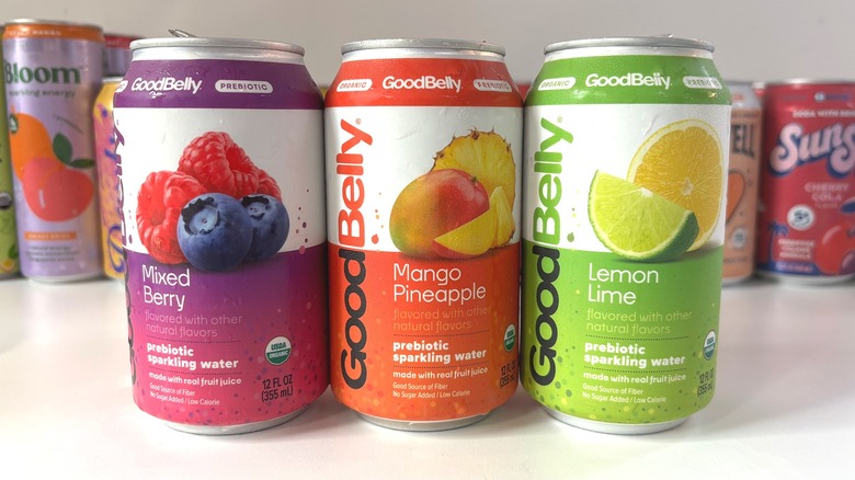 Three GoodBelly sparkling water cans lined up on white table