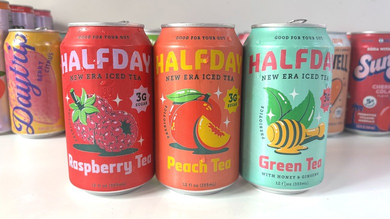 Three Halfday iced tea cans lined up on white table