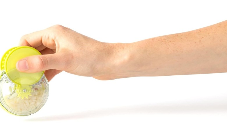 A person holding a Chef'n GarlicZoom garlic chopper