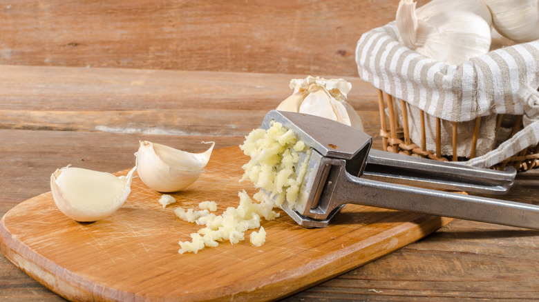 A garlic press on a cutting board