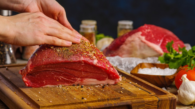 Rubbing seasoning on red meat