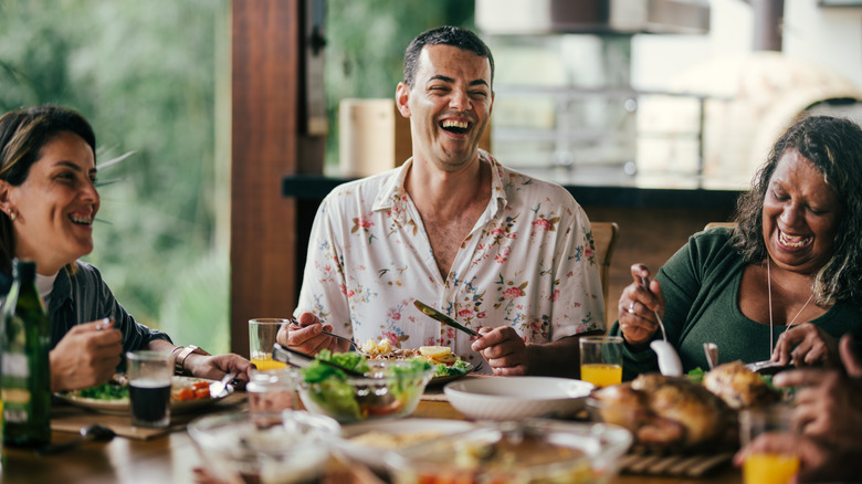 man laughing with friends outside