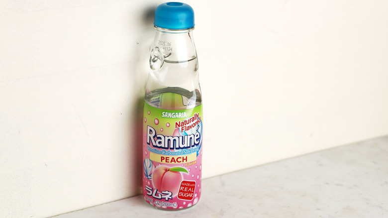 bottle of peach Ramune against a wall