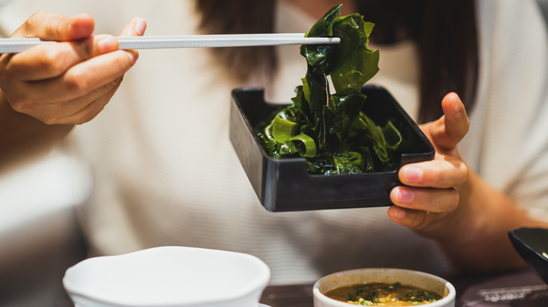 Woman eating kelp with chopsticks