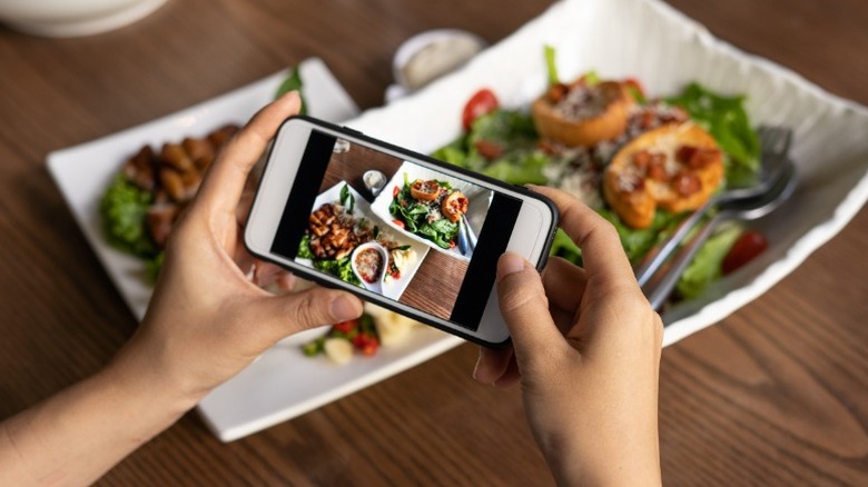 Hands taking a picture of food