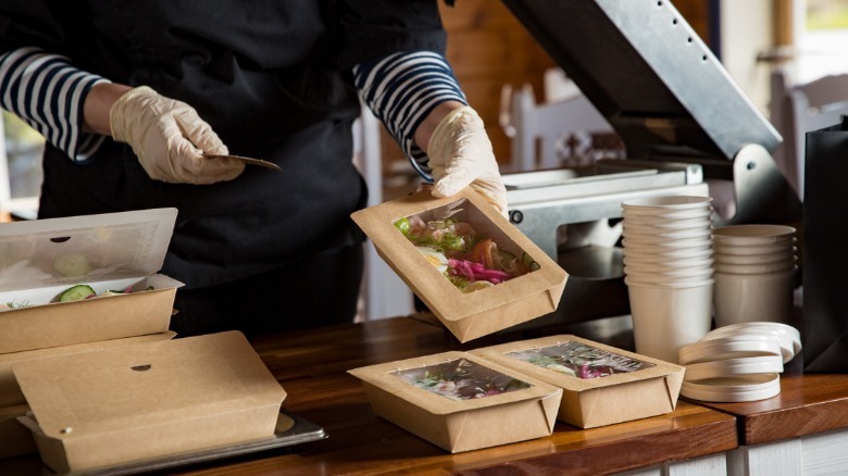 Chef with gloves packing takeout