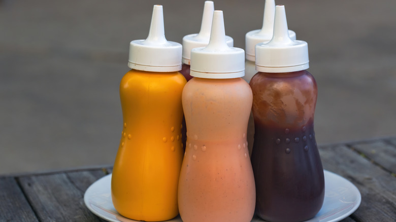A bunch of condiment bottles on a plate