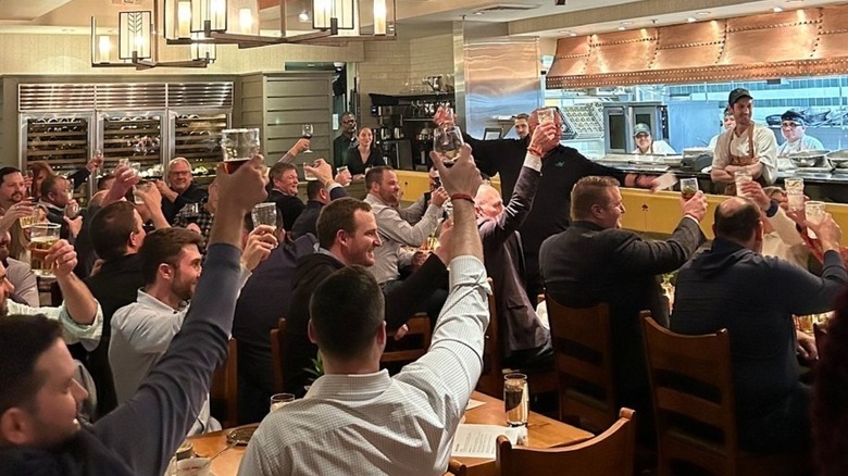 Restaurant patrons raising a cheer at The Green House restaurant.