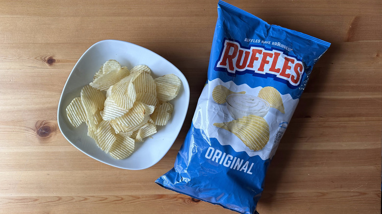 Original Ruffles bag with a bowl of chips on a wooden table