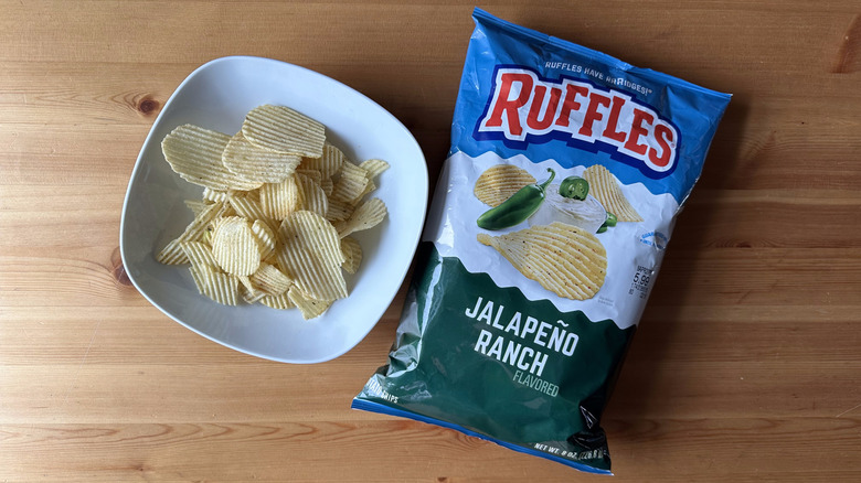 Jalapeño Ranch Ruffles bag with a bowl of chips on a wooden table