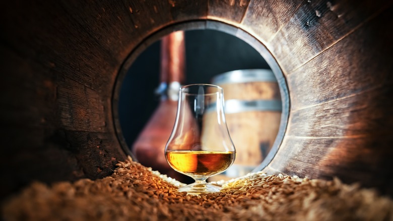 a glass of whisky inside a barrel