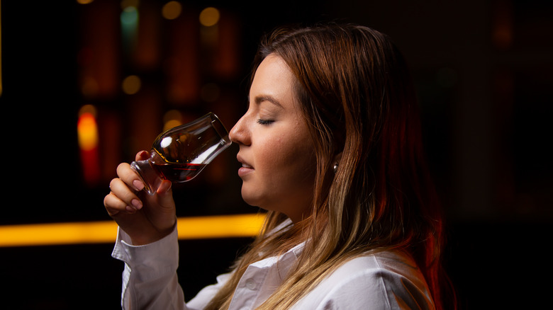 a woman smelling a glass of whisky