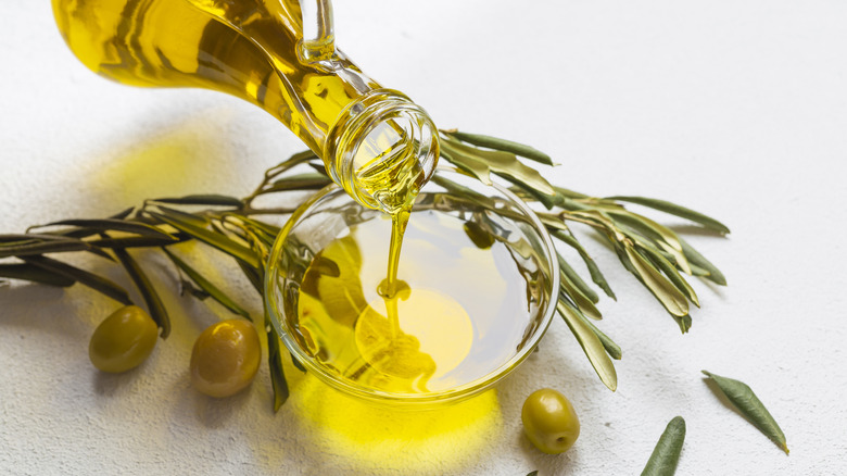 Pouring olive oil near olives