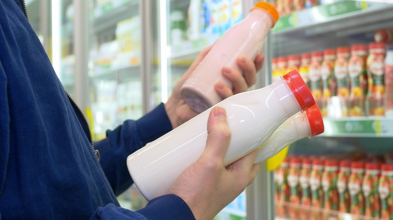 holding bottles of yogurt