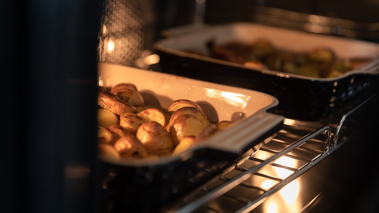 Potatoes in ceramic dishes roasting in oven