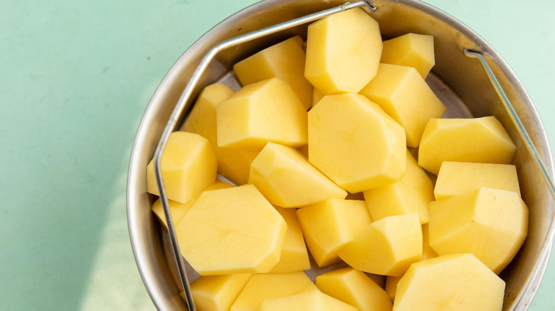 Chopped and drained potato chunks in metal bucket