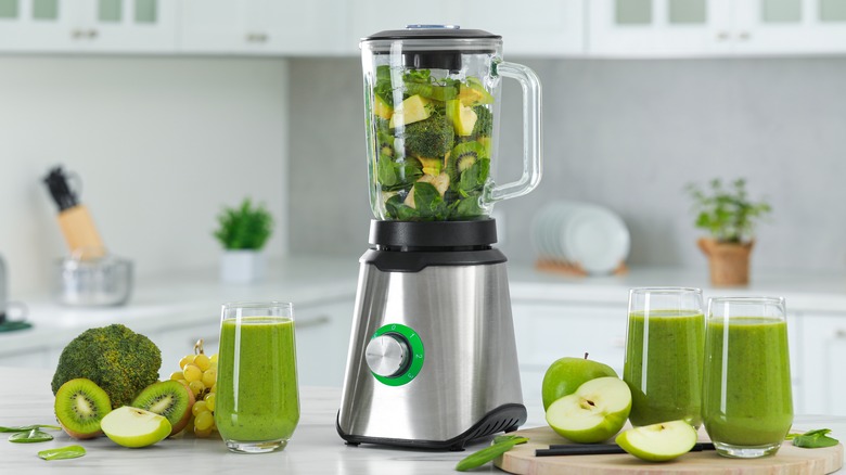 Blender filled with ingredients for a green smoothie