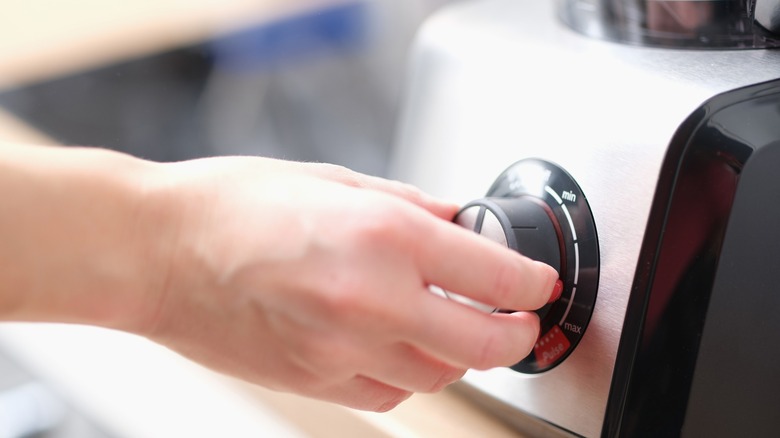 Person adjusting the speed of a blender