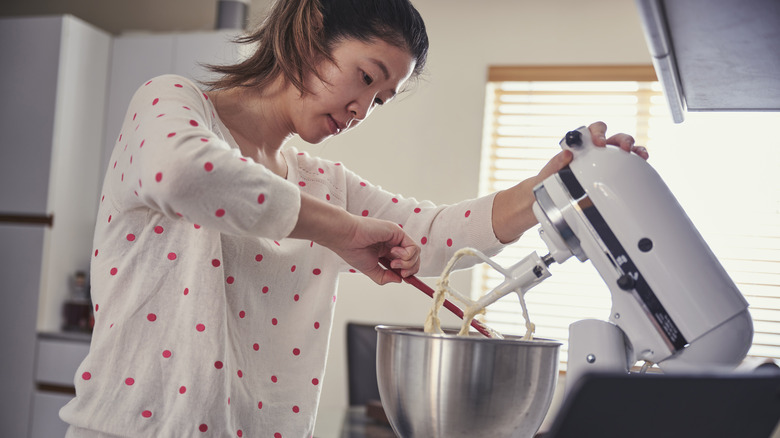 woman scraping down mixing bowl